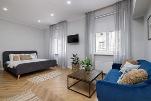 Una sala de estar con un sofá azul y una cama. en Feel Lviv! Old City Apartment, en Leópolis