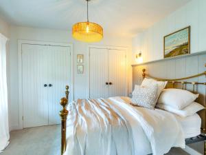 a bedroom with a bed and a chandelier at Appleby Barn in Lacock