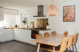 a kitchen with a wooden table and some chairs at Vakantiehuis Vliegend Hert Veluwe in Nunspeet