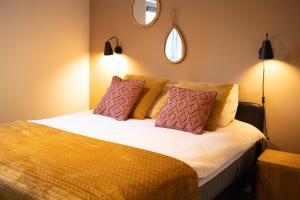 a bedroom with a large bed with two pillows at Vakantiehuis Vliegend Hert Veluwe in Nunspeet