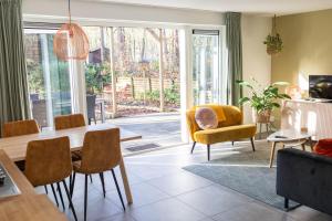 - un salon avec une table à manger et des chaises dans l'établissement Vakantiehuis Vliegend Hert Veluwe, à Nunspeet