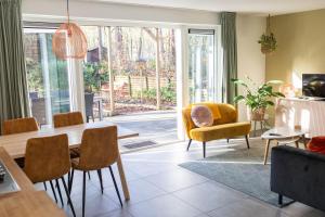 a living room with a dining room table and chairs at Vakantiehuis Vliegend Hert Veluwe in Nunspeet