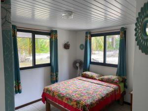 RotoavaにあるKoriKori House Fakaravaのベッドルーム1室(ベッド1台、窓2つ付)