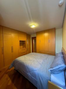 - une chambre avec un grand lit et des placards en bois dans l'établissement AP1407 - Região dos hospitais, piscina e garagem, à São Paulo