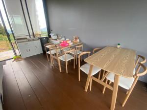 uma sala de jantar com uma mesa de madeira e cadeiras em บ้านอุ่นลมหนาว 