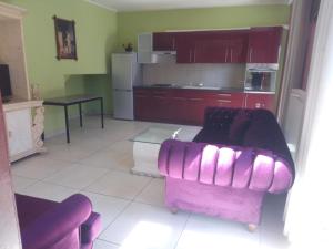 ein Wohnzimmer mit einem lila Sofa und einem Tisch in der Unterkunft Hôtel Rozafa in Charleroi