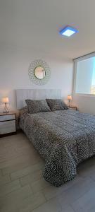 a bedroom with a bed and a mirror on the wall at Vive Alto Reñaca in Viña del Mar +49 photos