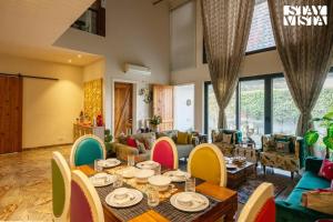 A restaurant or other place to eat at StayVista's Velvet Whisper - Urban Retreat with Contemporary Decor, Cozy Balcony & Lawn