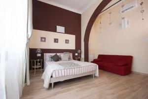 a bedroom with a bed and a red couch at Le Mie Stelle in La Spezia