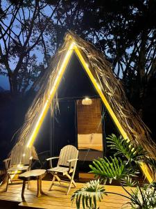uma tenda com duas cadeiras e uma mesa em ALMAH GLAMPING em Cali