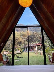 Cette chambre dispose d'une fenêtre offrant une vue sur un champ. dans l'établissement ALMAH GLAMPING, à Cali