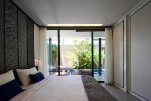 a bedroom with a large bed and a balcony at Adamare Villa Umalas in Kerobokan +126 photos