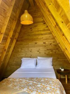 1 dormitorio con 1 cama en un ático de madera en ALMAH GLAMPING, en Cali