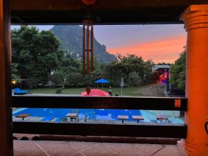 een raam met uitzicht op een zwembad bij Los Cruxes in Tepoztlán