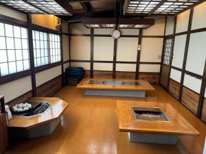 uma sala vazia com mesas e um relógio na parede em 山水民宿 em Takayama