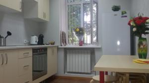a kitchen with white cabinets and a table and a window at Vagon in Barnaul