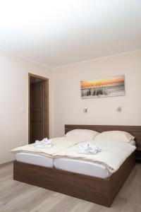 a bedroom with a large bed with white sheets at Relax & Therapy in Bad Tatzmannsdorf