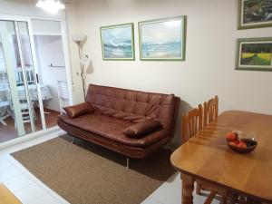 - un salon avec un canapé en cuir brun et une table dans l'établissement V&M Canet, à Canet d'En Berenguer