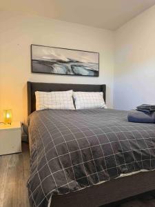 1 dormitorio con 1 cama grande con manta en Walking distance to St Boniface, easy parking, en Winnipeg