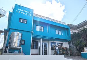 宮古島にあるMAHHO TERRACE MIYAKOの久島テラスを読む看板付きの青い建物