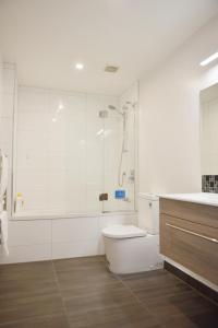 y baño blanco con ducha y aseo. en Johnsonville Brand New Lovely townhouse en Wellington