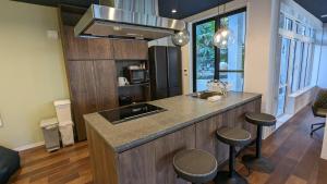a kitchen with a counter with a sink and stools at MAHHO TERRACE MIYAKO in Miyako Island
