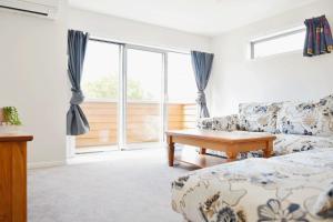 a living room with a couch and a table at Johnsonville Brand New Lovely townhouse in Wellington