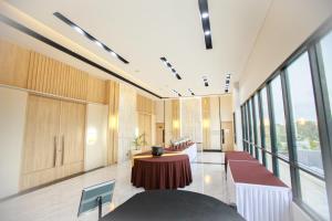 vestíbulo de oficina con mesa y ventanas grandes en Two K Azana Style Hotel Bengkulu en Bengkulu