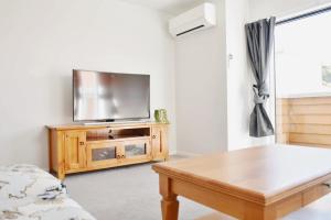 a living room with a tv and a coffee table at Johnsonville Brand New Lovely townhouse in Wellington