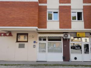 un edificio con puertas blancas y un edificio de ladrillo en Apartment Vanja 1 - near city center en Krapina