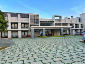 a large building with a parking lot in front of it at VAGA NAKSHATHRA SUITES in Vagamon