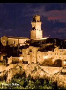 um edifício no topo de uma colina com uma torre em Casa Della Rosa em Pitigliano