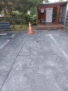 un cono de tráfico naranja sentado en un estacionamiento en Rural in the city, en Palmerston North