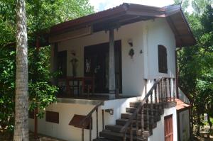 a house with stairs to the front of it at The Waves Beach Chalets in Tangalle