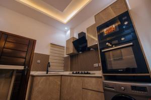 a kitchen with a stove and a microwave at Big chill stays (luxe suits) in Maijaw