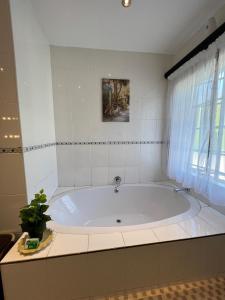 a large bath tub in a bathroom with a window at The Silver Gates Bed and Breakfast in Mbabane