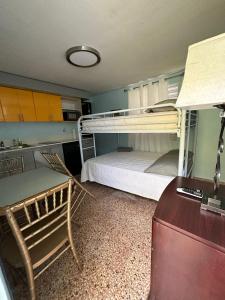 Kleines Zimmer mit einem Etagenbett und einem Schreibtisch. in der Unterkunft Beach Getaway with Cozy 2 Bedrooms near the Ocean, Arecibo in Arecibo
