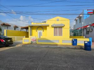 una casa amarilla al lado de una calle en Beach Getaway with Cozy 2 Bedrooms near the Ocean, Arecibo, en Arecibo