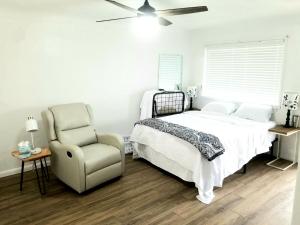 een slaapkamer met een bed en een stoel en een plafondventilator bij Lakeview Luxury Resort in Lakeview
