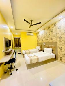 1 dormitorio con 2 camas, escritorio y ordenador en Hotel Saayein Residency en Siliguri