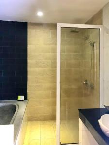 uma casa de banho com um chuveiro e um lavatório. em Ra-Ta Boutique Hotel em Siem Reap