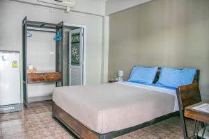 a bedroom with a large bed with blue pillows at CHADA HOUSE in Chiang Mai