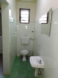 a white bathroom with a toilet and a sink at Cingaki Hotel in Mombasa