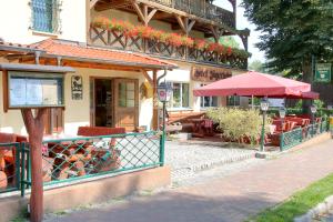 a restaurant with tables and an umbrella on a street at Hotel am Liepnitzsee in Wandlitz