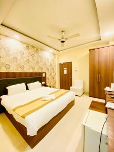a bedroom with a large bed and a bathroom at Hotel Saayein Residency in Siliguri
