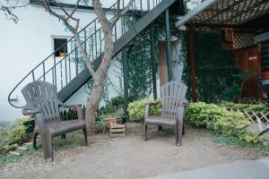 dwa krzesła siedzące przed domem w obiekcie Tequila Sunrise Hostel w mieście Gwatemala