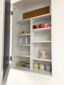 a white cabinet with bowls and cups in it at Mansarda (B13) Belfiore in Turin