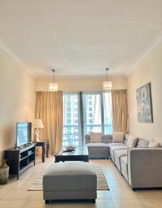 - un salon avec un canapé et une télévision dans l'établissement Lovely 1 bedroom apartment for vacations, à Dubaï
