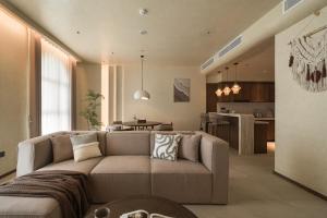 a living room with a couch and a kitchen at Su Casa Phu Quoc Long Beach in Phú Quốc
