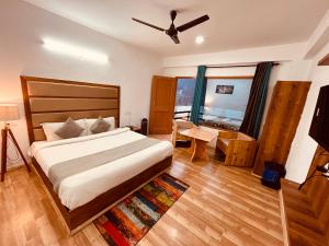 a bedroom with a bed and a large window at Manali Hotel Beas River Retreat in Manāli